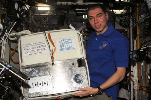 Sergei Volkov prepares to launch the mini-satellite - Image credit NASA