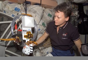 Expedition 5 flight engineer Peggy Whitson KC5ZTD holds one of the two amateur radio antennas in the Unity node on the ISS. The antennas were installed during a spacewalk scheduled on August 22, 2002